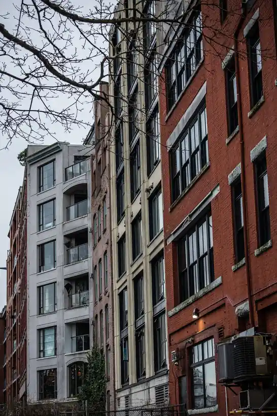 Historic red brick warehouse facade contrasting with modern glass architecture