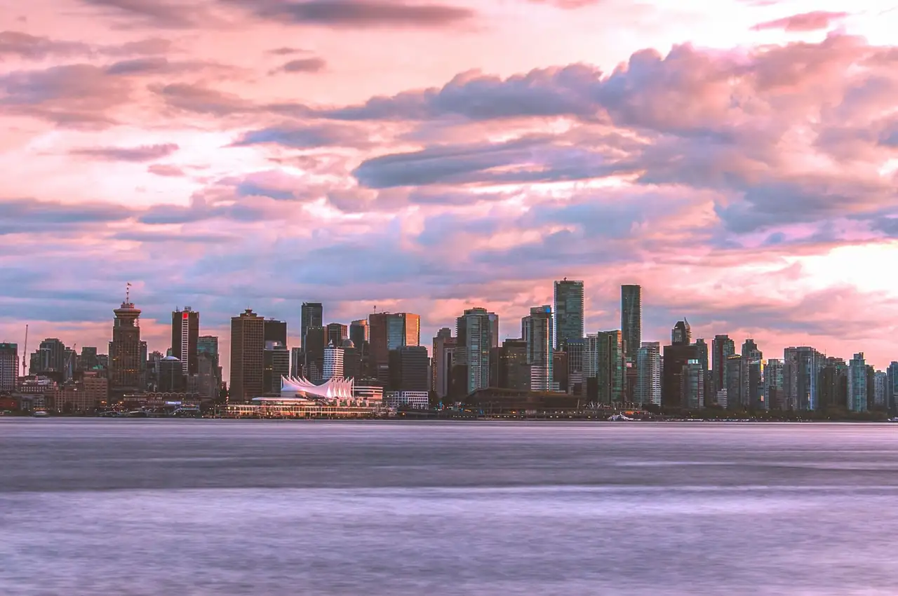 Breathtaking view of Vancouver skyline with sunset clouds and calm sea