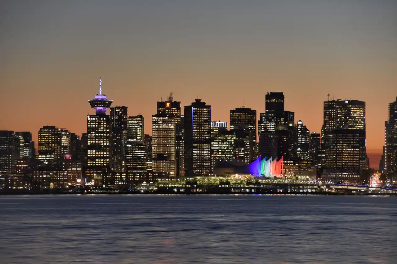 Vancouver city skyline illuminated during evening twilight with calm waters