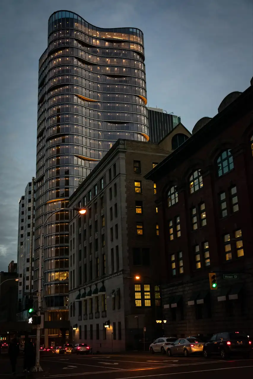 Modern downtown skyscraper with sleek reflective glass towering above street level