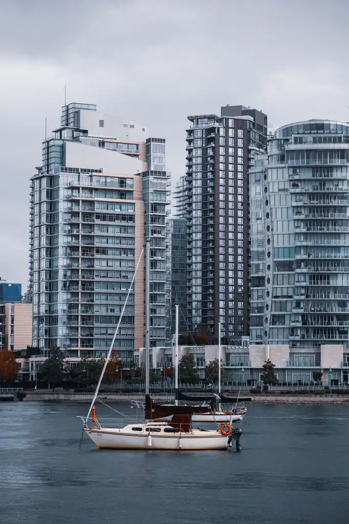 Sailboat on calm waters in front of Vancouver modern residential towers