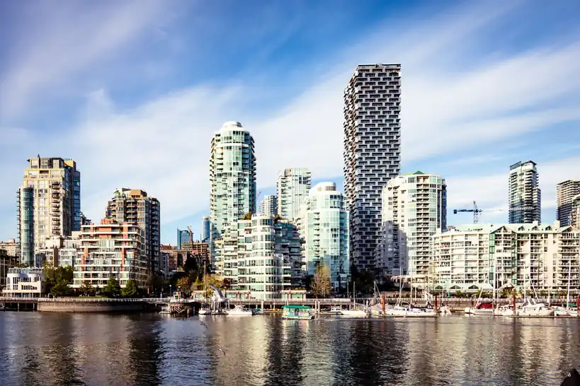 Vancouver cityscape featuring modern skyscrapers along the waterfront under blue sky