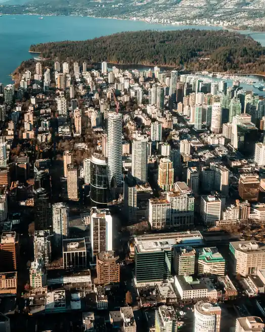 Aerial view of Vancouver's urban skyline against coastal waters and mountain backdrop