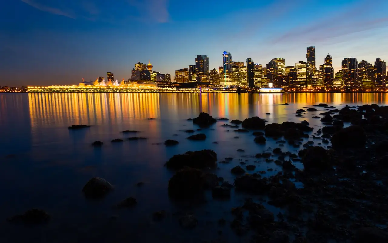 Vancouver waterfront skyline at dusk with reflections along the harbour