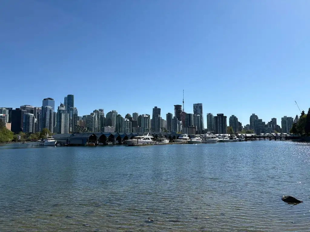 Vancouver waterfront promenade along Coal Harbour overlooking anchored boats and mountains